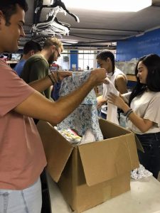 Students from local colleges help sort clothes for the Downtown food and clothing bank.