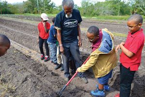 White Harvest Farm Director William Byrd with students from St. Clara Evans School