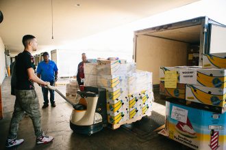 Feeding Northeast Florida warehouse worker Cosme Corona loads items into a partner agency’s truck.