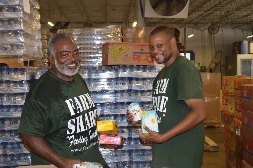 Karey Gee and Alex Hagans sort food at the Farm Share warehouse on Jessie Street in Jacksonville.