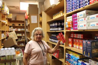Volunteer Elaine Furman stocks the shelves in the Max Block Food Pantry at Jewish Family & Community Services.