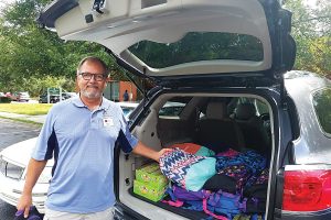 Lutheran Social Services volunteer Jeff Viau delivers backpacks filled with nutritious food to students in a learning center in an apartment complex.