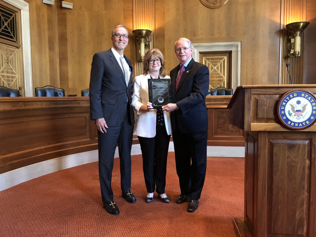 AHTCC President Michael Gaber looks on as Sulzbacher President and CEO Cindy Funkhouser receives the Charles L. Edson Tax Credit Award from Rep. John Rutherford.