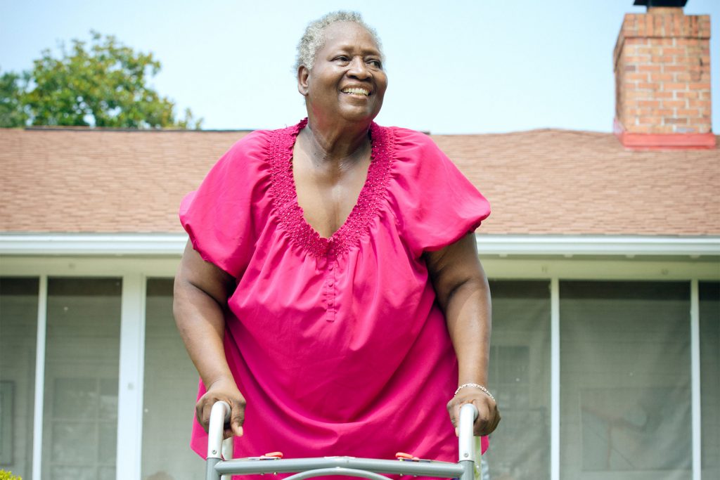 woman walking outside with walker | Center for Independent Living