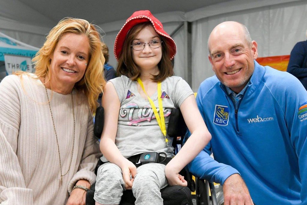 Jim and Tabitha Furyk with young smiling girl in wheelchair
