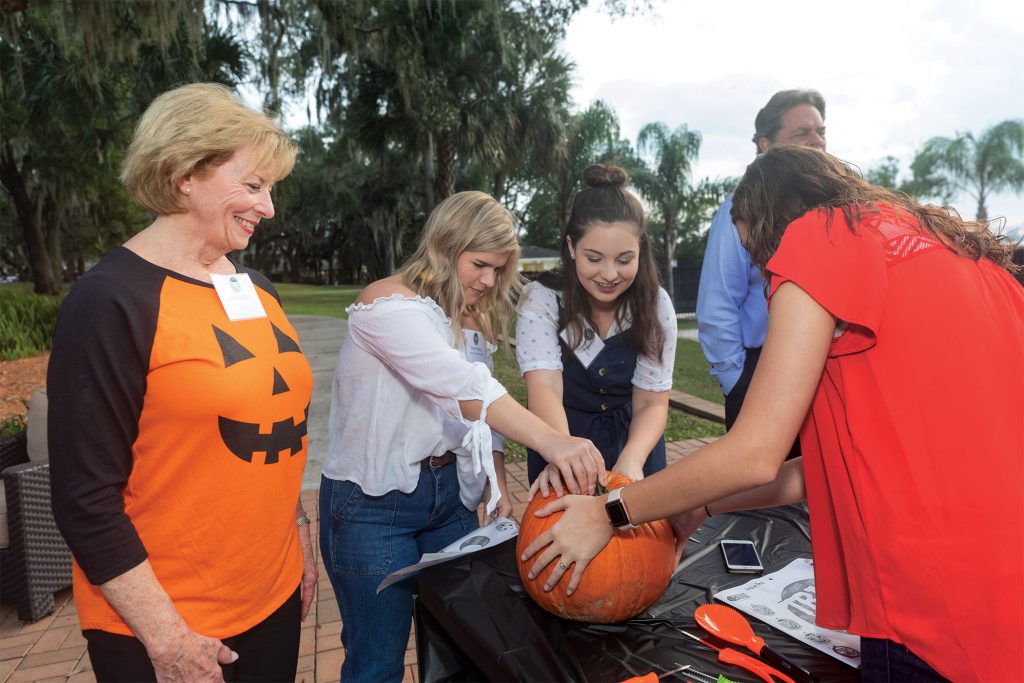 Jennifer Glock with scholarship students at a pumpkin-carving event