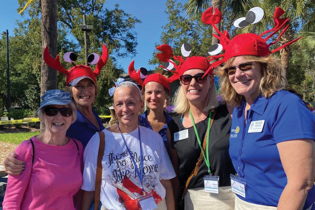 group of smiling women with crab hats