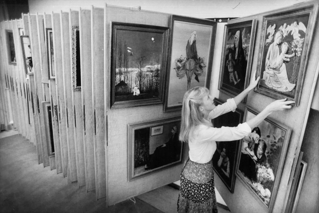 older black and white photo of woman looking through panels of framed images | Photo/Bo Rader, The Florida Times-Union